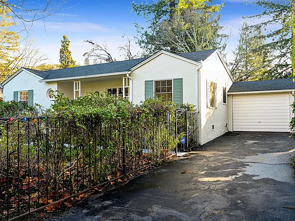 Street view of house with attached garage and driveway.