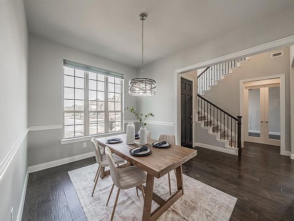 Dining room featuring baseboards, stairway, dark wood finished floors, french doors, and a notable chandelier