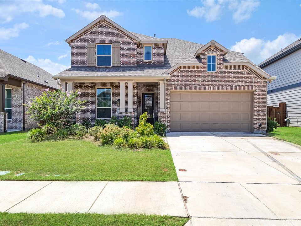 Two-story brick exterior featuring a covered entry, an attached garage, and a concrete driveway