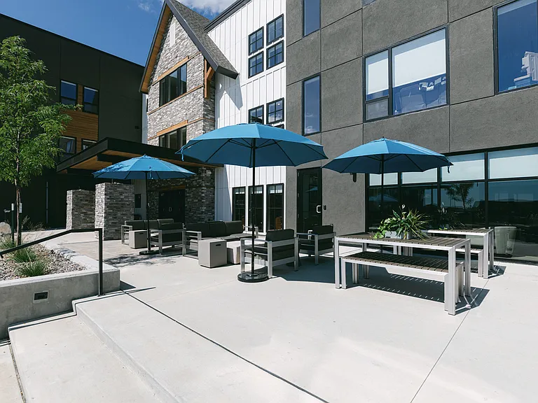 Welcome to The Earl Twin Homes, where modern design meets outdoor comfort. Enjoy relaxing on the spacious patio under vibrant umbrellas, perfect for gatherings or quiet moments. Come see what makes this community specialschedule your visit today!