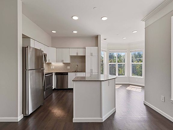 Modern kitchen design with sleek finishes and dark wood flooring