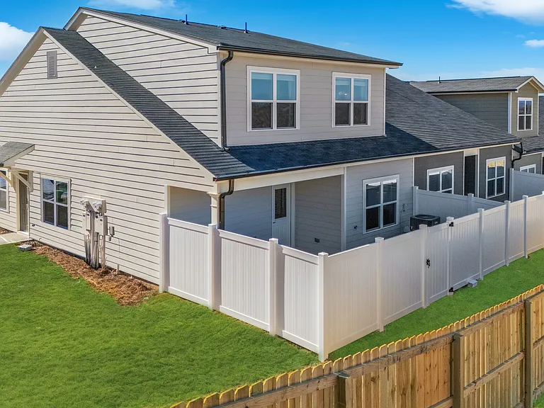 Back exterior of the ranch-style, cottage homes. Showing the fenced-in backyards.