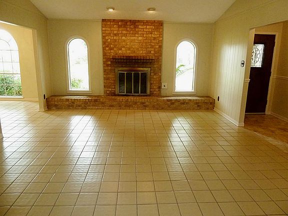 The brick surrounded fireplace adds an inviting touch to the den.