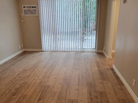 Large living area with floor to ceiling window. AC included.