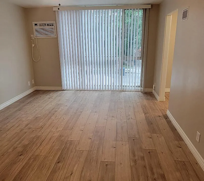 Large living area with floor to ceiling window. AC included.