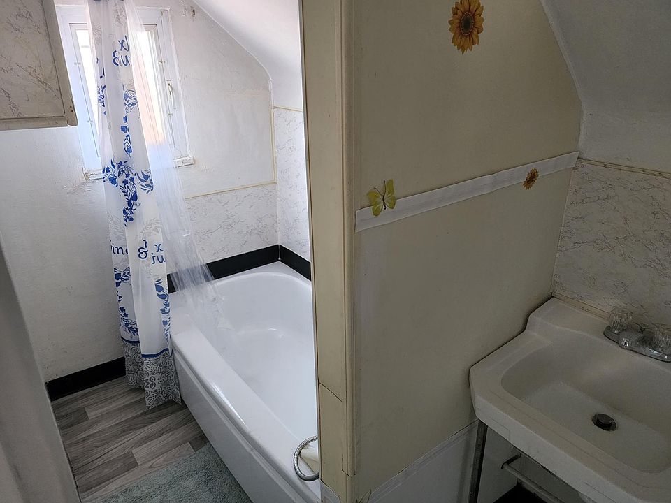 Bath with shower. Storage cabinet on wall opposite bath tub.