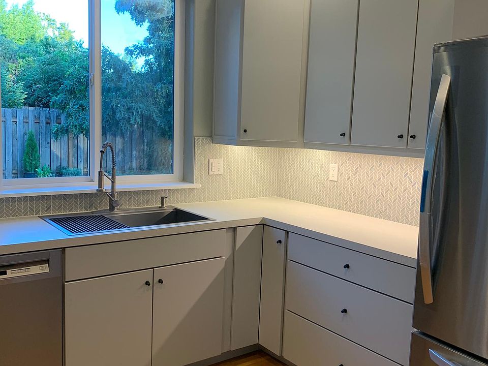 Bright kitchen with under counter lighting and garden view.
