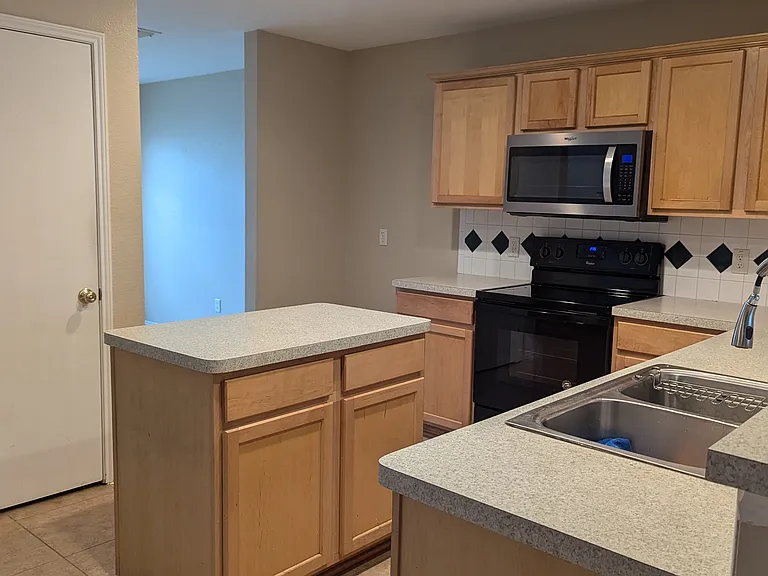 Kitchen with island. Formal dining room is in front of the house through the left entry way.