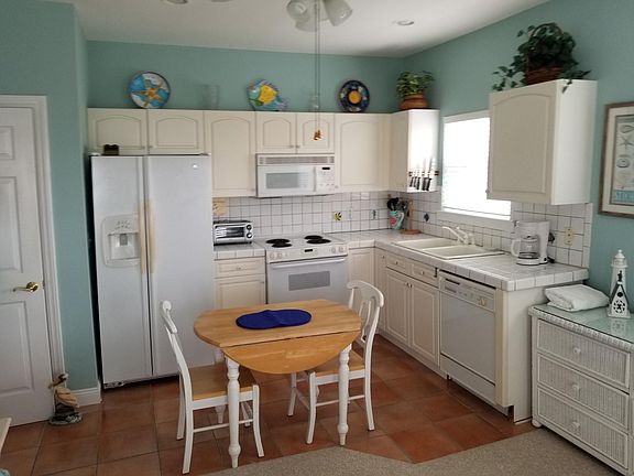 Fully equipped kitchen includes dishes and cookware.