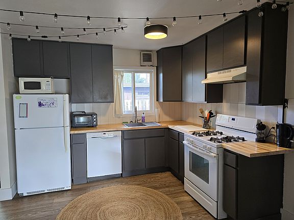Newly refreshed eat-in kitchen with gas range and new tile backsplash. Well stocked with pots and pans and other cooking and baking basics.