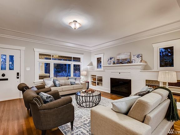Original built-ins with leaded glass flank the fireplace in the large living room inside the entry.