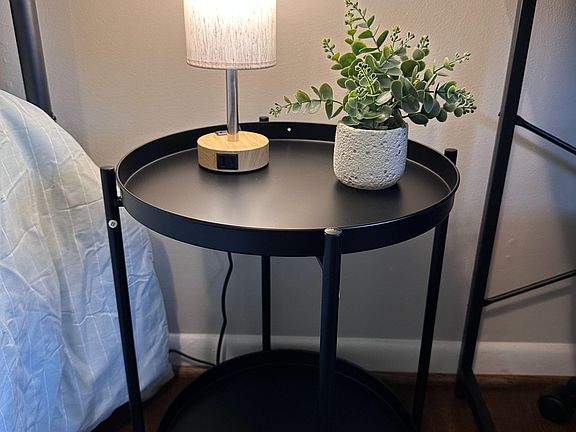 Touch-screen lamp with dimmed lighting options and bedside table with storage.