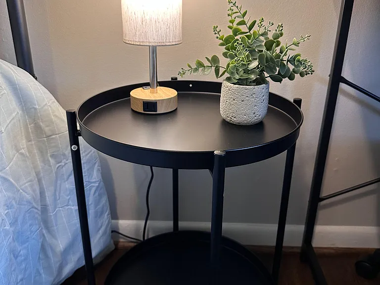 Touch-screen lamp with dimmed lighting options and bedside table with storage.