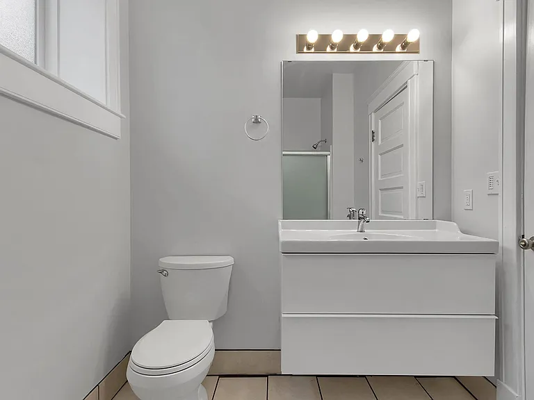 Bathroom - floating vanity, frosted glass by-pass shower doors, tiled floors, money-saving vent fan on a timer