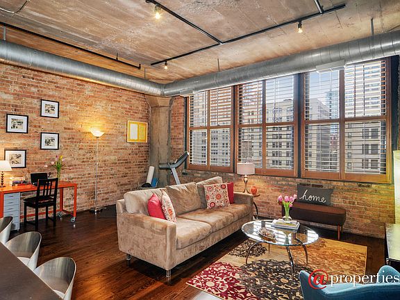 Living room with oversized windows & exposed brick
