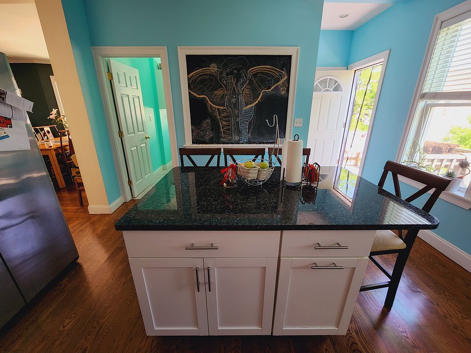 kitchen with chalkboard wall, granite counters, dishwasher, fridge, laundry room and access to balcony