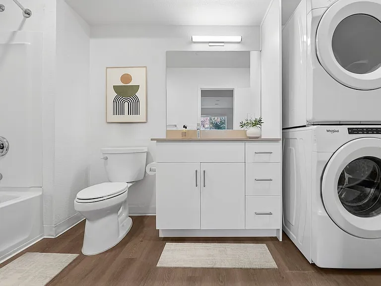 Renovated Package bath with beige quartz countertops, white cabinetry, and hard surface flooring