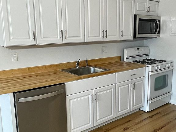 Brand new cabinets, butcher block counter tops, dishwasher, gas stove, and over-the-range microwave