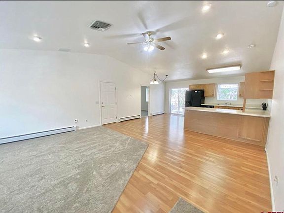 Living area on the left. Kitchen, dining area and bar. Bonus room left of kitchen. Sliding door to backyard.