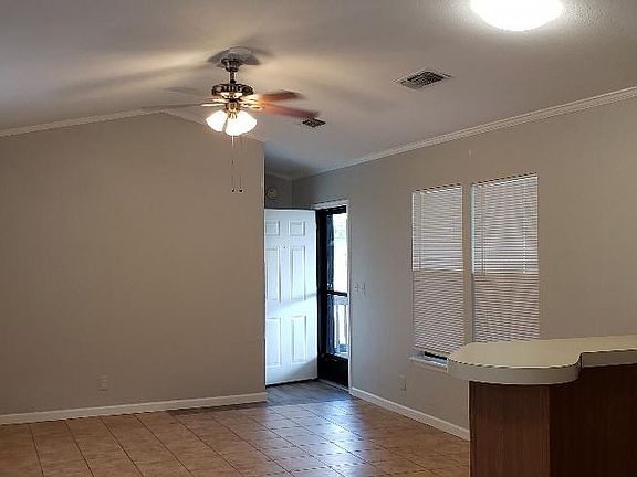Open concept view of living room from dining area. Front door open in rear.