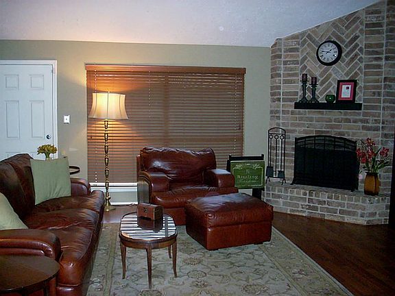 Family room w/ fireplace and polished wood floors.