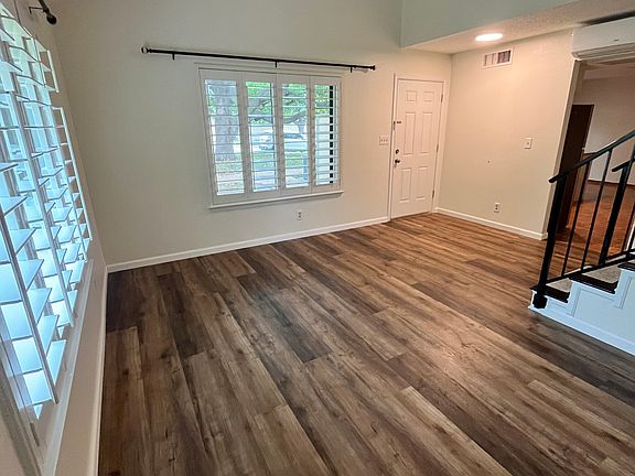 living room has shutter-style blinds and high ceiling
