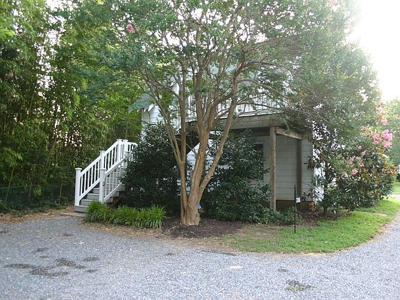 Parking beside entrance to apartment. Lights in trees to light the parking area. Flood lights on the corner of the building to l