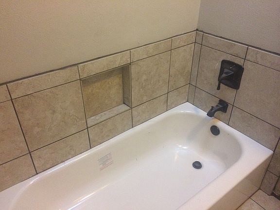 new tub, tile, faucet, built in soap dish