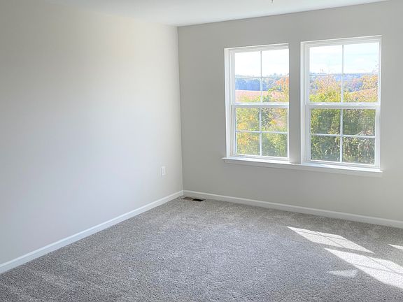 Carpeted owner s suite with double window in a DRB Homes York II Garage home in the Homestead Acres