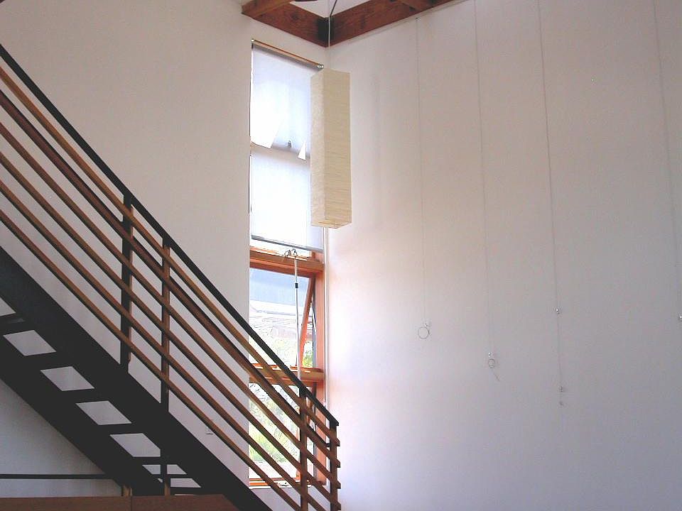 Living area with 16 ft ceilings with clerestory skylight above. The stairs go up to the loft bedroom and walk-in closet.