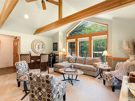 Spacious formal living room with large window and exposed beams.