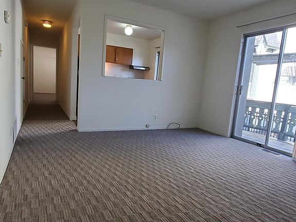Living room looking toward kitchen and BR with deck through sliding glass doors