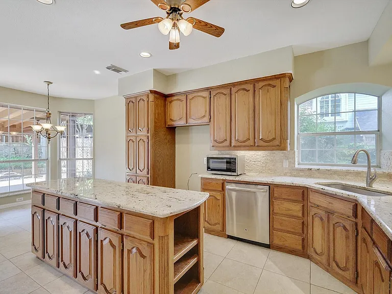 Kitchen featuring a central island with granite countertop, wood cabinetry, and stainless steel appliances