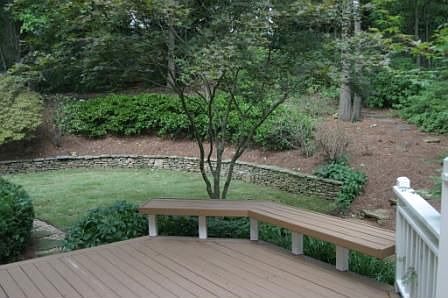 Two level deck with lush landscaping.