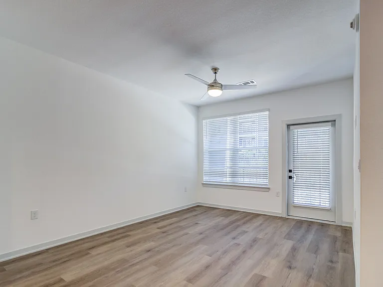 Wood-style plank flooring, a ceiling fan and overhead light, and a large window with a door leading to your own private patio or balcony makes Garrett Forum a bright and open home to make your own.