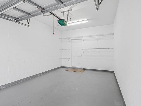 View looking into the garage with access to the laundry room and into the condo. Wire shelves available for keeping your items organized and easy to reach.