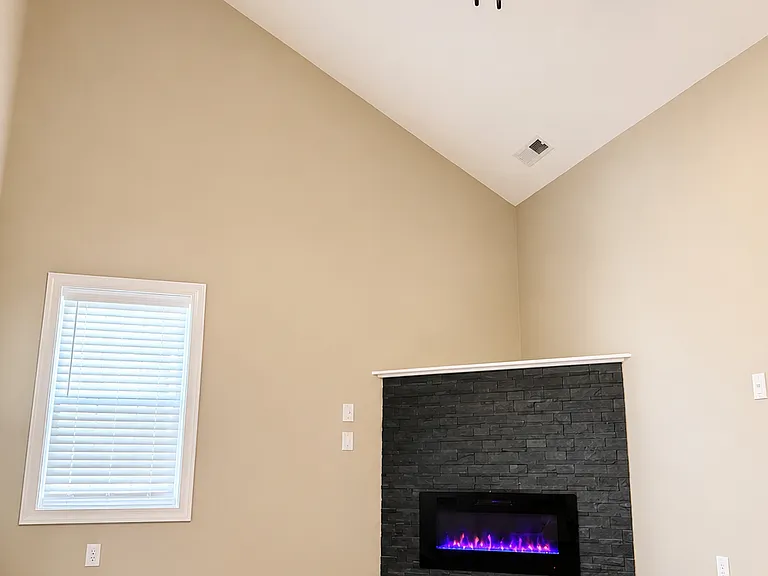 Living room with ceiling fan & electric fireplace.
