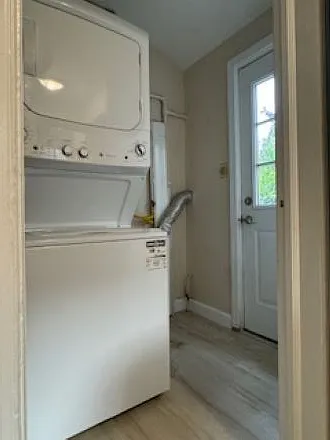 Laundry room (1 year old washer-gas dryer combo unit), door to backside patio.