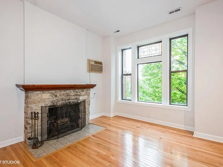 Living room with fireplace and large front windows that provides great natural light