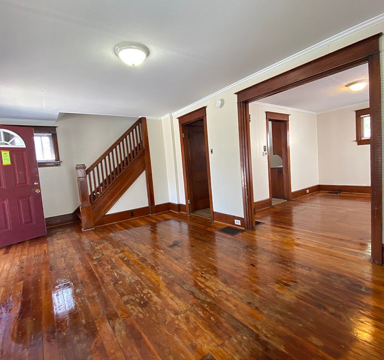 View of the front door, staircase and dining room while in the living room.