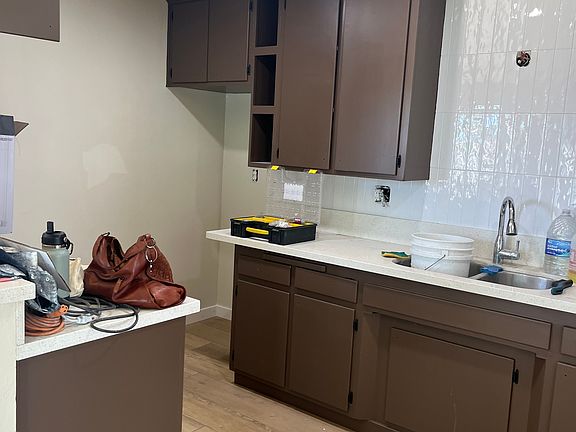 Chocolate kitchen Cabinet's, New vertical tile. New refrigerator and stove/oven just arrived!