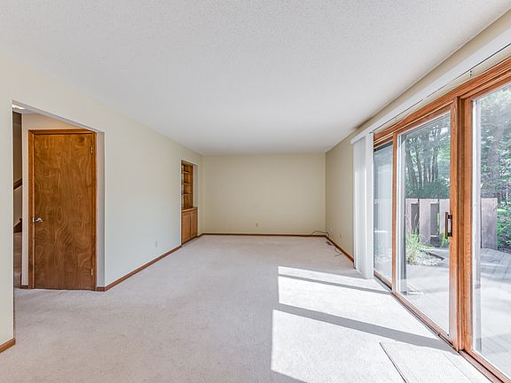 Living room with built in storage and shelving. The large glass sliders lead to the nice size deck.