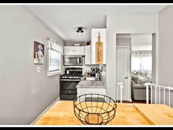 Recently renovated kitchen with updated lighting fixtures, fresh paint,modern cabinets , and generous space for cooking and dining essentials.