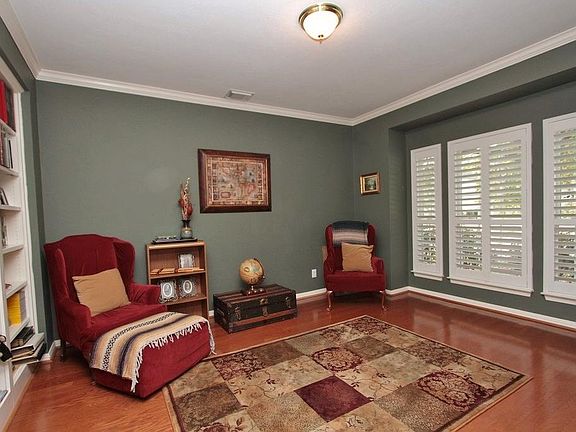 French doors off the foyer open into this private Study. It features large picture windows with Plantation shutters, hardwood floors and custom bookcases.