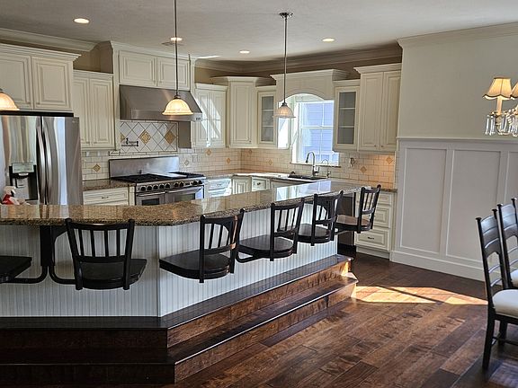 Gourmet kitchen with large hooded range, gas and electric ovens and Bosch dishwasher.