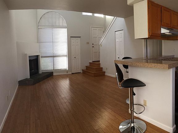 Open floor plan with breakfast bar separating great room from kitchen. Living room has 20 foot ceiling and large overhead fan.
