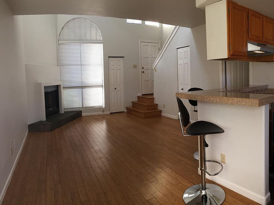 Open floor plan with breakfast bar separating great room from kitchen. Living room has 20 foot ceiling and large overhead fan.