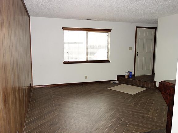 Front door of 3415 and living room window. Newer wood-look tile in herringbone pattern.