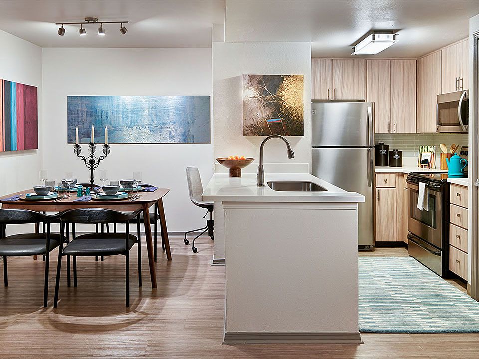 Apartment Kitchen with Stainless Steel Appliances and Dining room and with wood flooring.