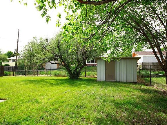 Fully fenced backyard with sprinkler system and metal storage shed. Plenty of summer shade from trees on south side of house.
